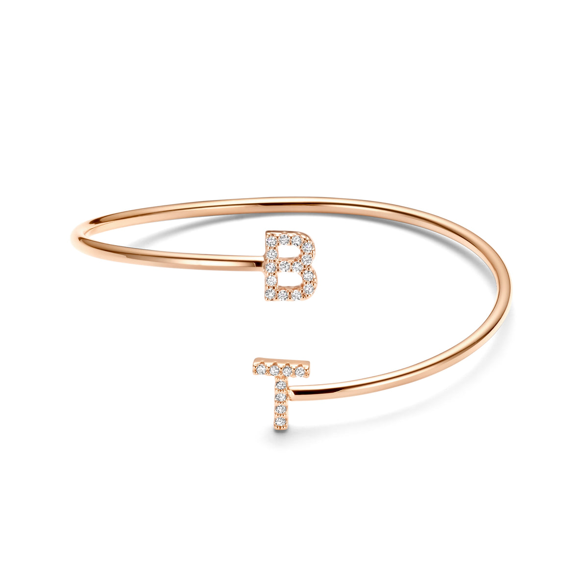 Een rosékleurige Twisted-armband met verspringende uiteinden en glinsterende letters B en T op wit.