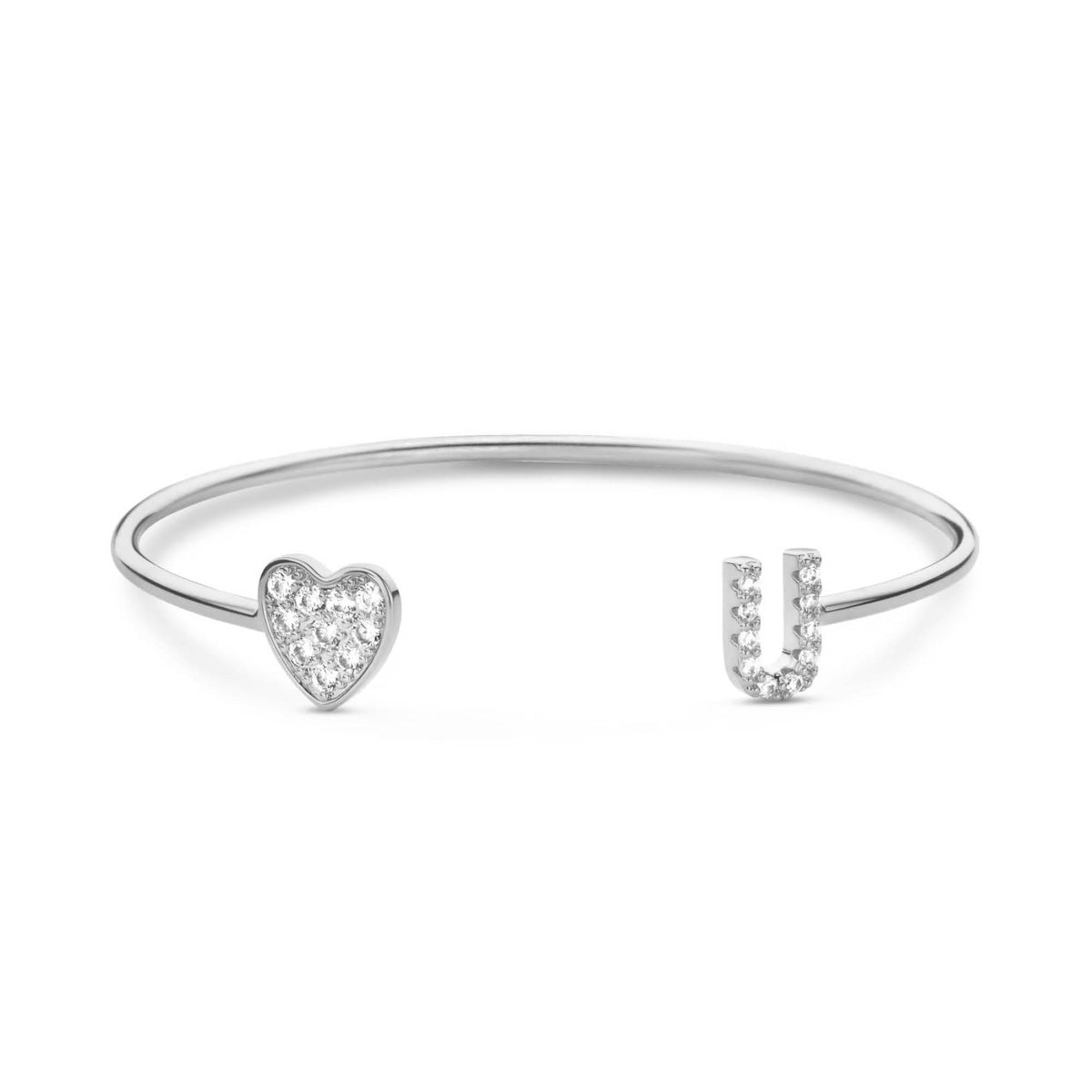 Een open zilverkleurige armband met een glinsterend hartje en een letter aan de uiteinden.
