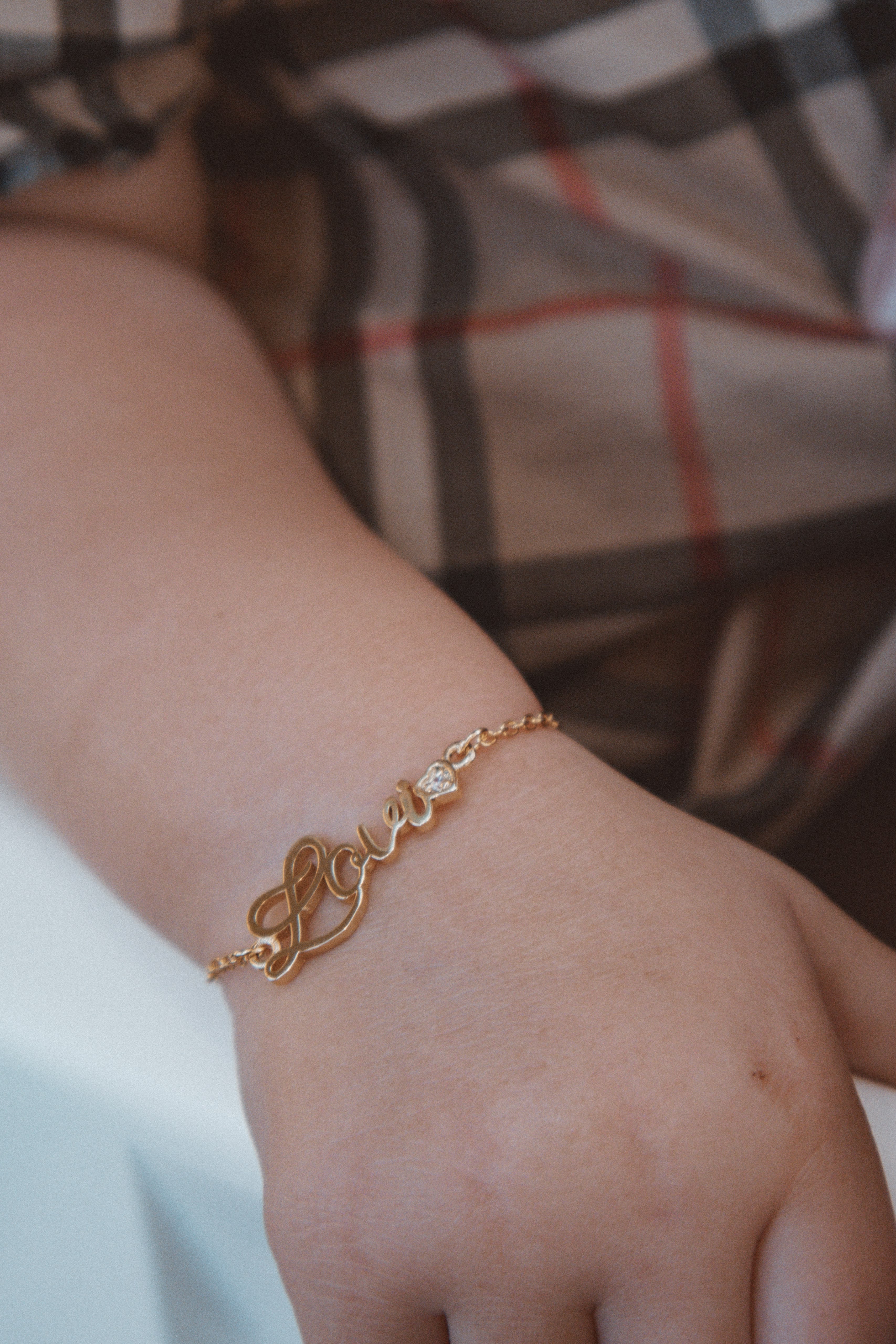 Echte close-up van de Lovi Baby bracelet met naam en hartvormig steentje